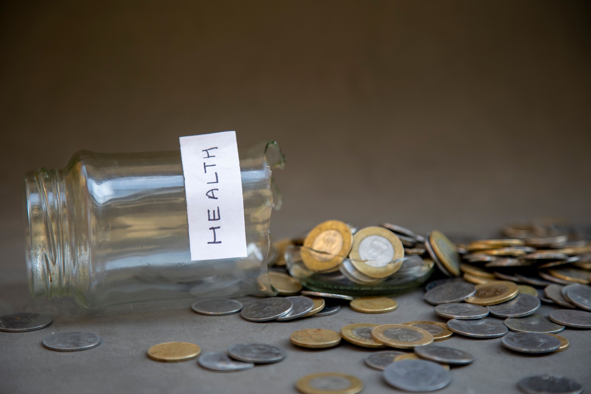 Spilled Jar of Coins With Health Label Emphasizing Budget and Financial Planning